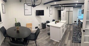 A modern kitchen with white cabinetry, a black countertop island, and a black and white patterned rug. - Spacious Home Airport 10 Min (East Point)