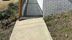 Un corridoio coperto con un muro in mattoni da un lato e una struttura in legno dall'altro.