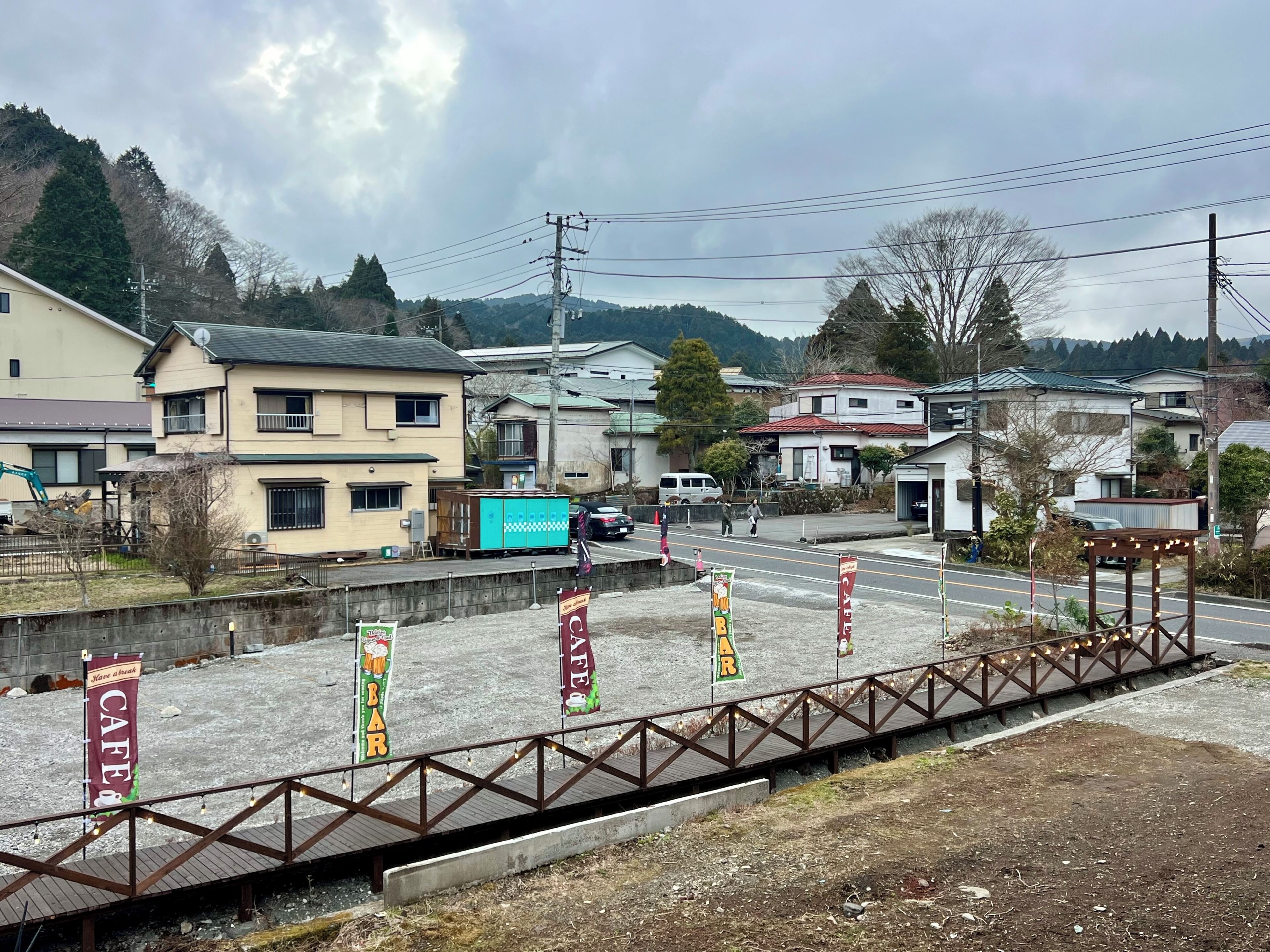Ein Wohngebiet mit Häusern, einer gepflasterten Straße und einer Fußgängerbrücke.