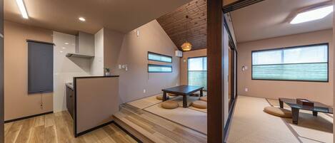 A modern interior with tatami flooring, a wooden ceiling, and a minimalist design.