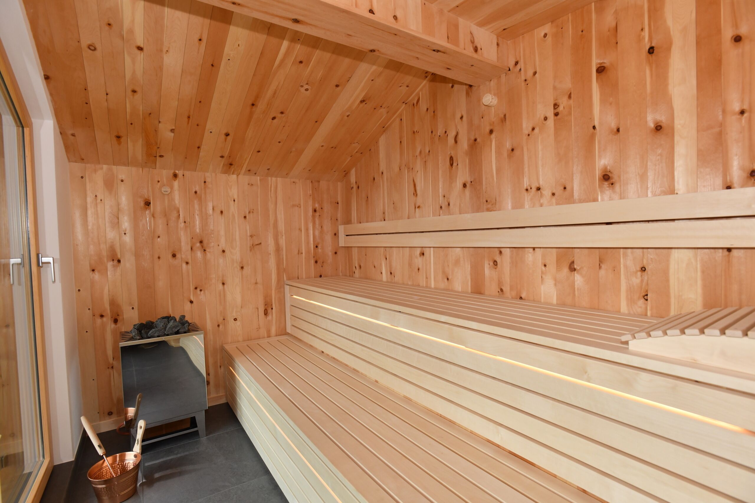 Ein Saunaraum mit Holzwänden und Bänken.