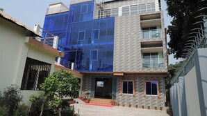 A modern building with a glass facade, stone exterior, and multiple balconies. - Kishoreganj Haor Resort (Kishoreganj Sadar)