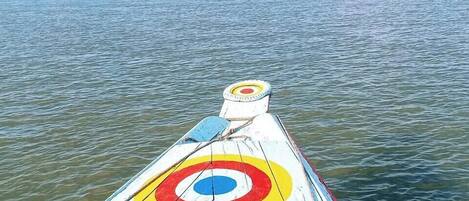 A boat with a colorful target design on its side, floating on calm water.