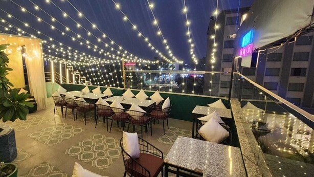 Een terras met sfeerverlichting, tafels en stoelen.