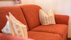 En rød sofa med puder med blomstermønster.