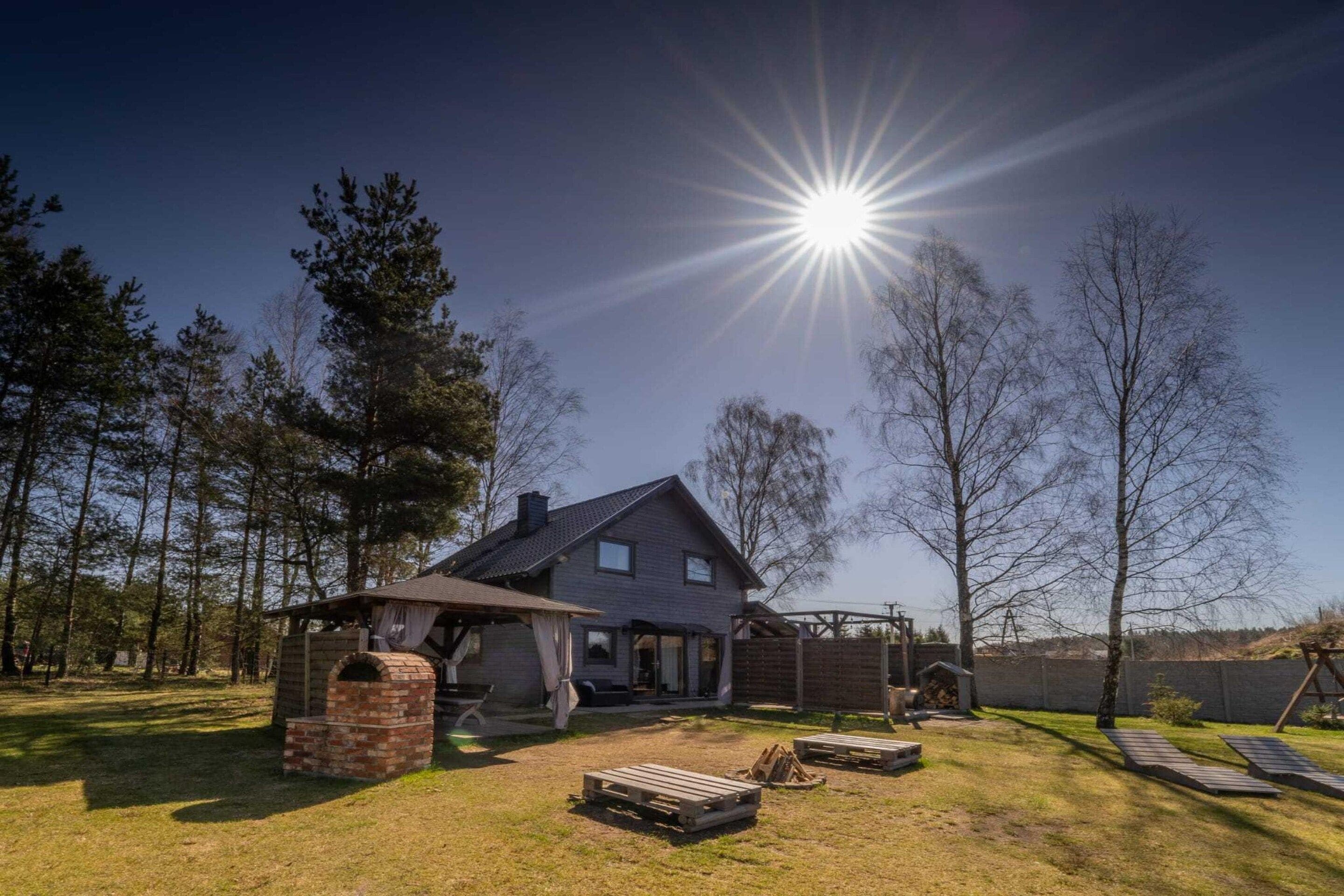 Ein Haus mit Schornstein, Grillplatz und einer Holzterrasse.