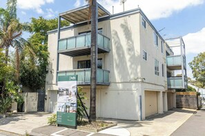 A multi-story residential building with balconies, a gated entrance, and a signboard. - Spacious 1BDR in St Kilda Near Tram and Beach (St Kilda)