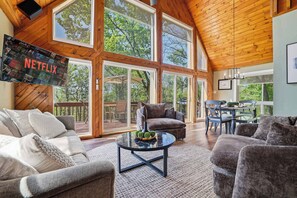 A spacious living area with a large TV screen, comfortable seating, and a view of the outdoors. - Views of Blue Mountain! Near App Trail, Game Room (Palmerton)