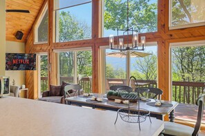 A spacious room with large windows, a wooden ceiling, a dining table set with placemats, and a television displaying the Netflix logo. - Views of Blue Mountain! Near App Trail, Game Room (Palmerton)