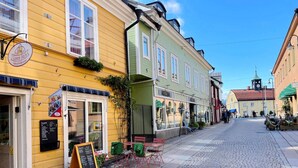 Eine Kopfsteinpflasterstraße gesäumt von bunten Häusern, darunter eine Gelateria und ein Café.