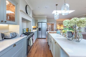 A kitchen with a refrigerator, stove, and various appliances. - Beautiful 5BDR 3Bath Home in Barnes (Greater London)