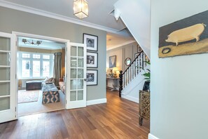 Un vaste espace de vie doté d’un plancher en bois, d’un escalier et offrant une vue sur l’extérieur.