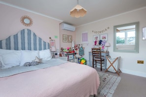 A bedroom with a bed, a desk, a chair, a window, and wall decorations. - Beautiful 5BDR 3Bath Home in Barnes (Greater London)