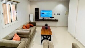 Una sala de estar moderna con televisor de pantalla plana, sofás y una mesa de centro.