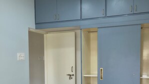 Ein Schlafzimmer mit einem Bett, einem Kleiderschrank und einem Deckenventilator.