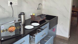 Eine moderne Küche mit schwarzem Arbeitsplatz, einer Edelstahl-Spüle und einem integrierten Geschirrspüler.