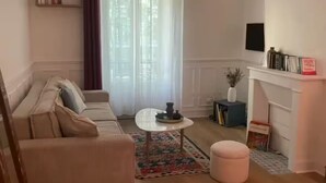 Ein Wohnzimmer mit einer Couch, einem Couchtisch und einem Fernseher.