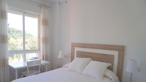 Une chambre à coucher avec un lit, un bureau et une lampe.