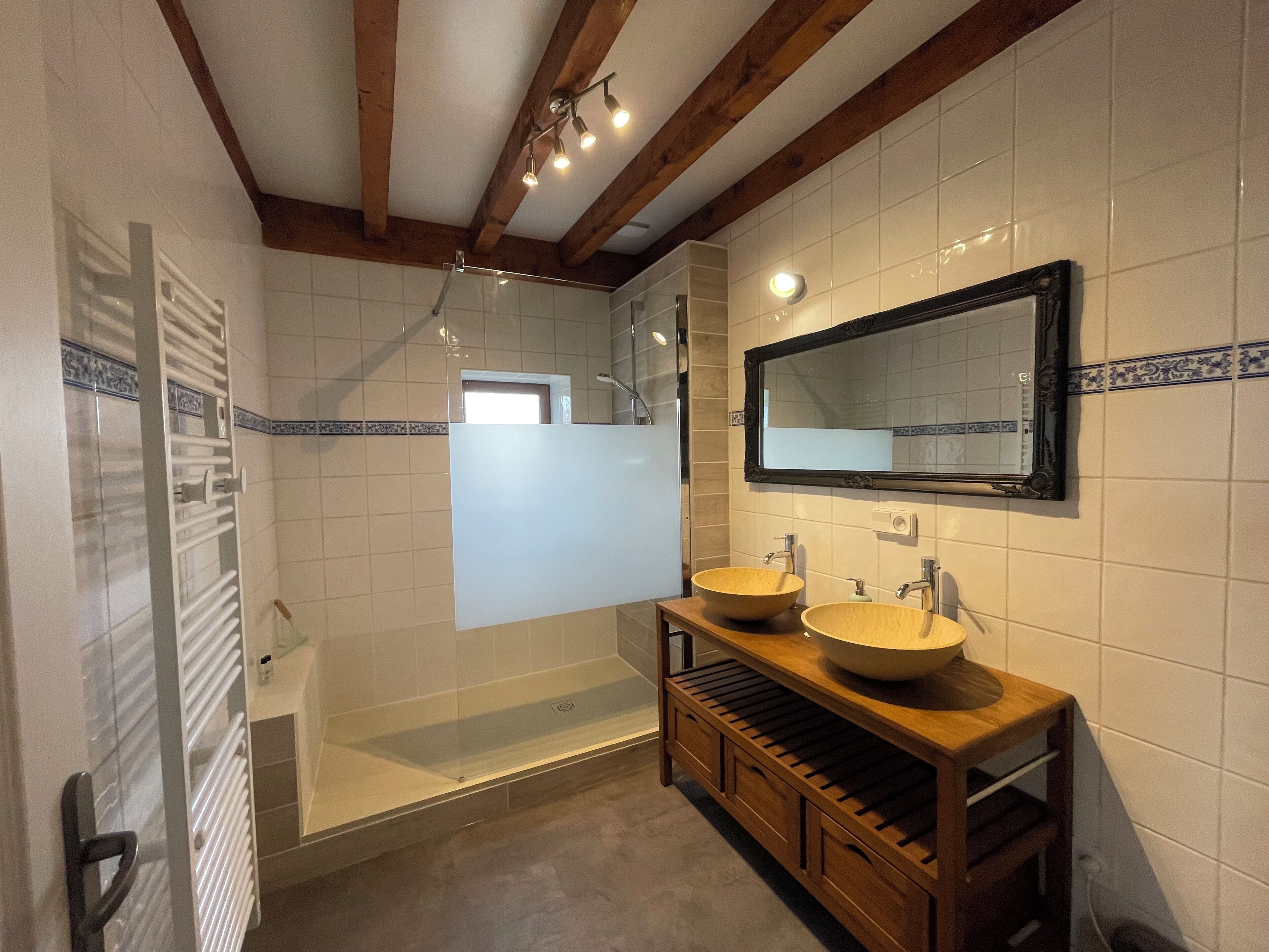 Un baño con dos lavamanos, un espejo y una ducha.