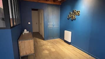 Una habitación con paredes azules, un armario de madera, una puerta y un radiador.