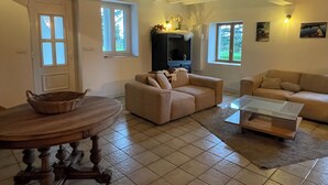 Una sala de estar con un sofá, una mesa y un televisor.