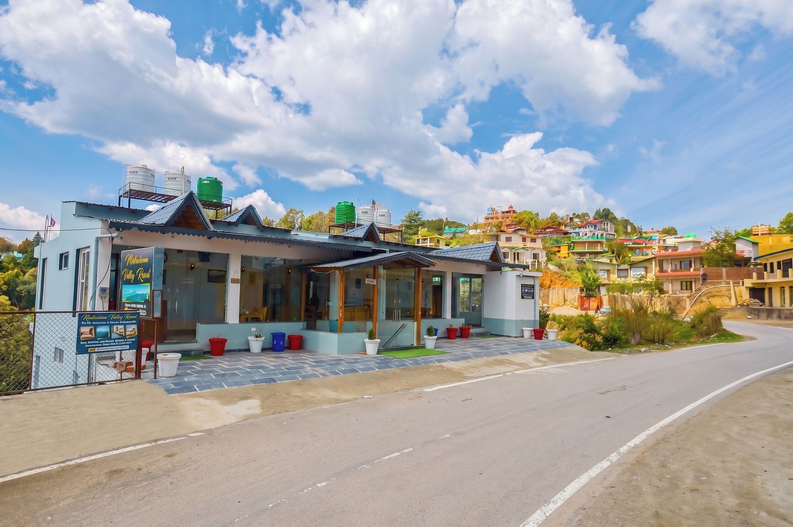 A hotel with a modern design, a covered outdoor seating area, and a view of the surrounding hillside.