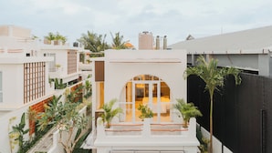 A modern hotel with a central courtyard, multiple balconies, and lush greenery. - Uma Avaya Villas Canggu (Canggu)