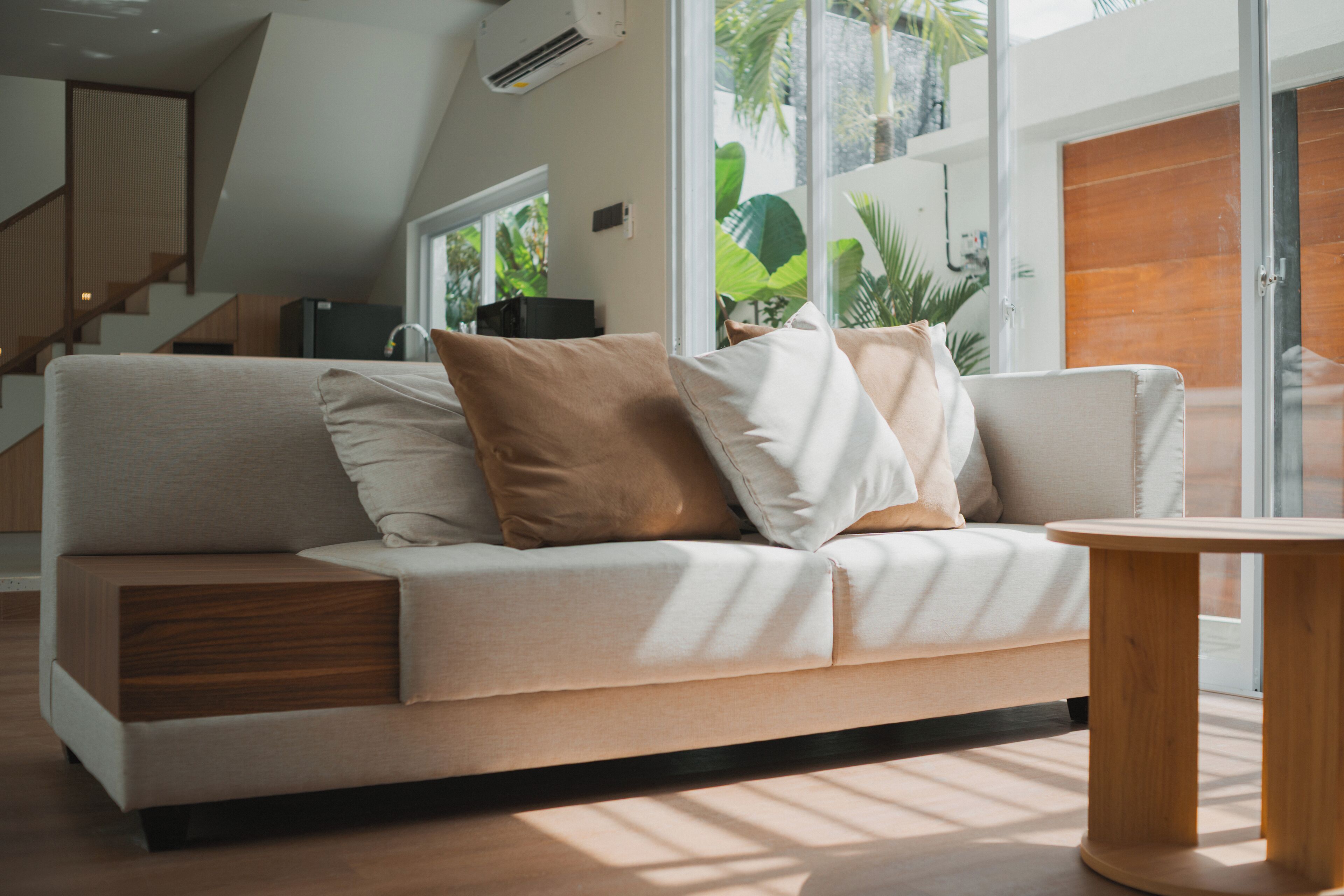 A modern living room with a sofa, a coffee table, and a staircase leading to an upper level.