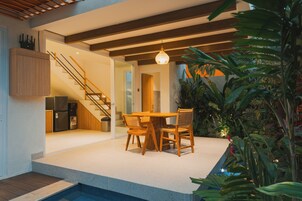 Una cocina moderna con refrigerador integrado, armarios de madera y una escalera que sube a un nivel superior.