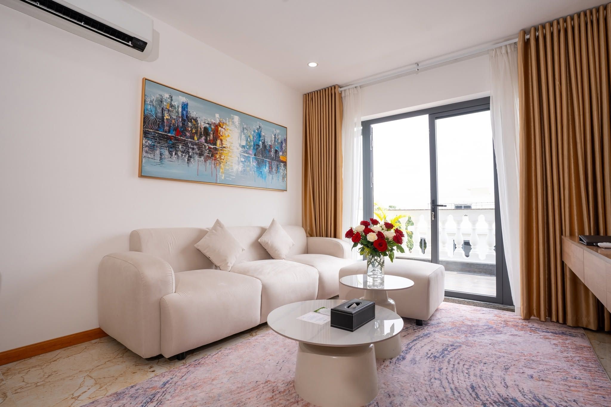 A modern living room with a sofa, a coffee table, and a painting on the wall.