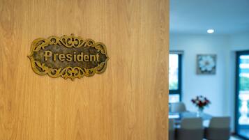 Une porte en bois ornée d’une plaque en laiton sur laquelle on peut lire le mot « Président ».