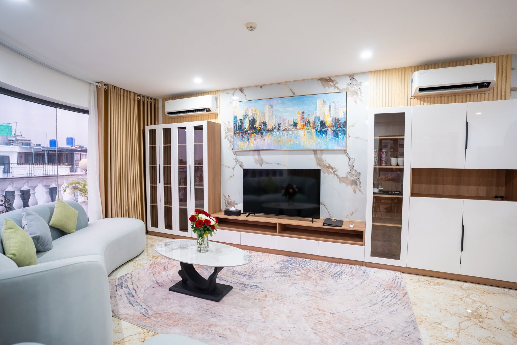 A modern living room with a sofa, a coffee table, a TV, and a painting.