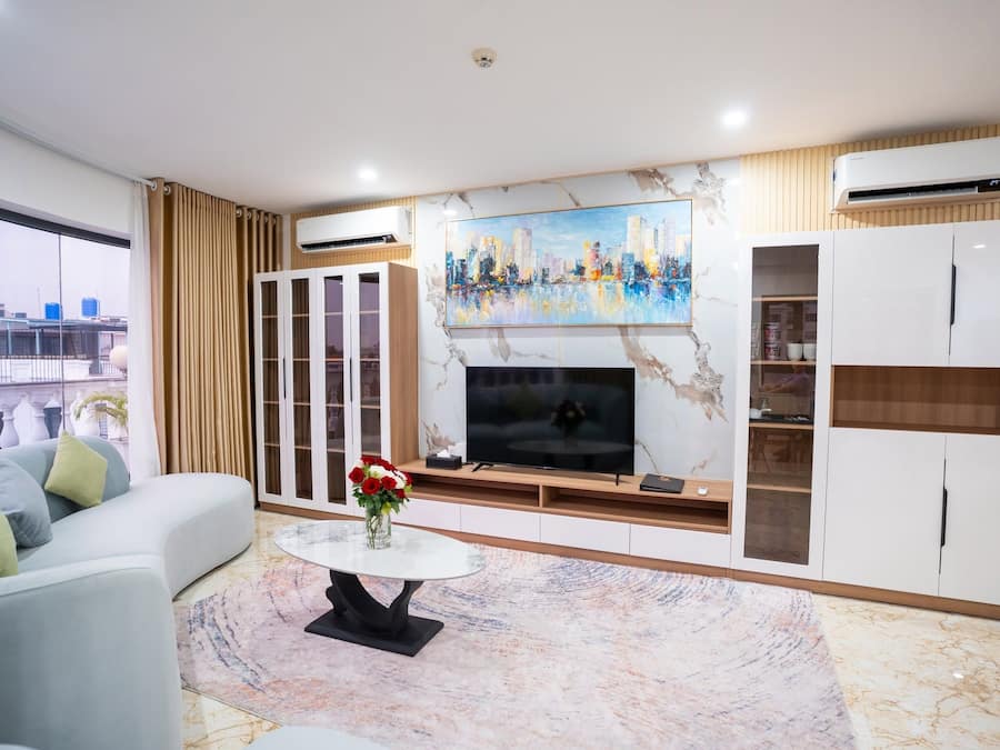 A modern living room with a sofa, a coffee table, a TV, and a painting.