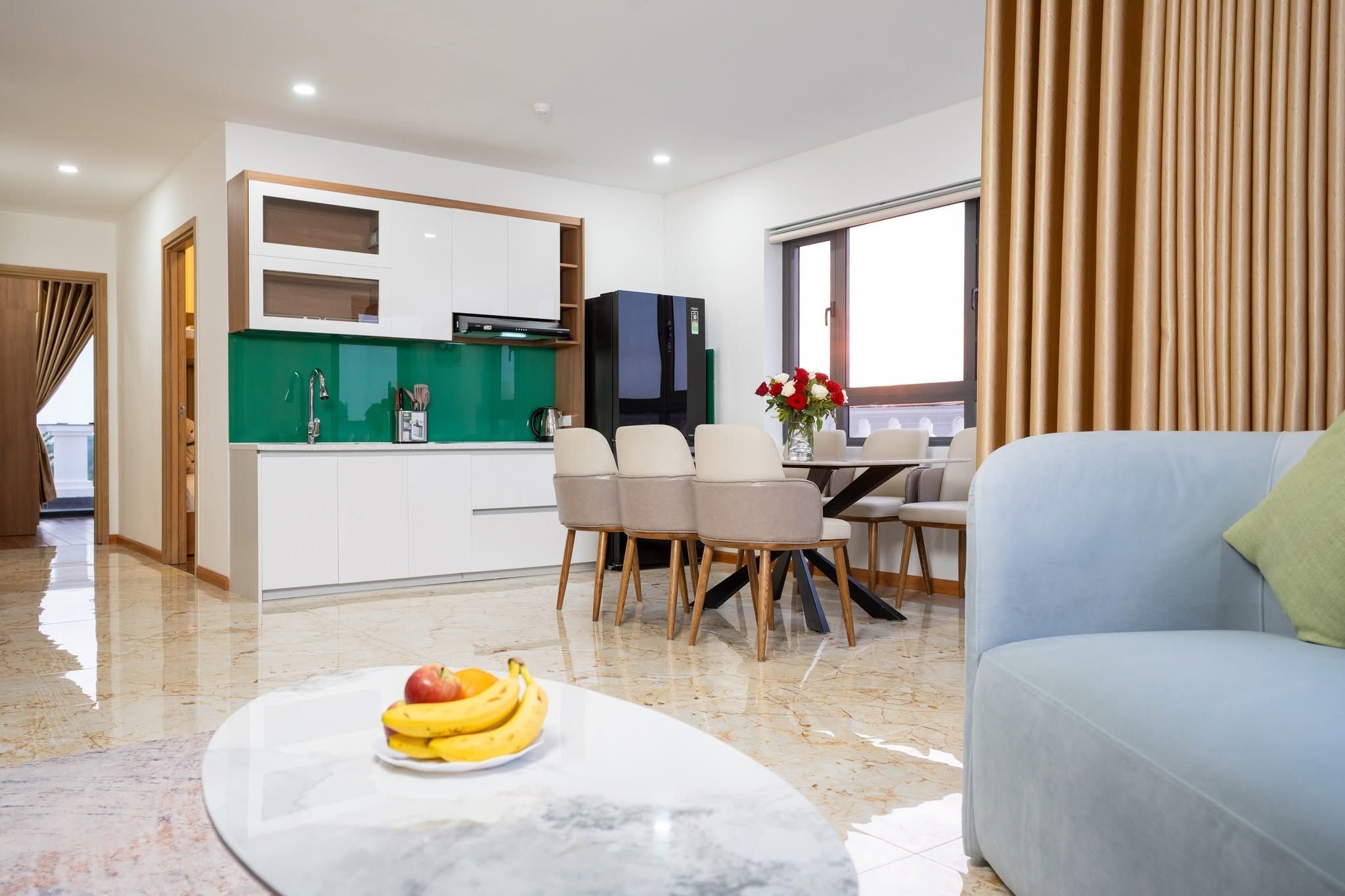 A modern living room with a marble coffee table, a sofa, and a dining area with chairs and a table.