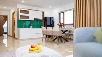 A modern living room with a marble coffee table, a sofa, and a dining area with chairs and a table.