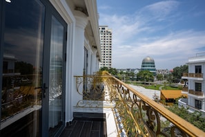 Un balcon donnant sur un immeuble de grande hauteur et une structure en forme de dôme.