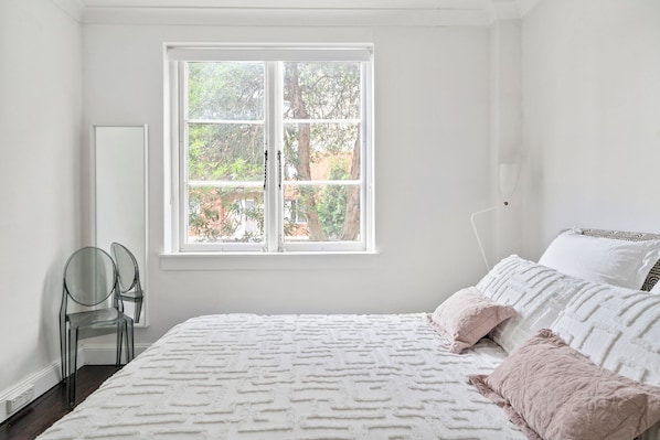 A bedroom with a bed, a window, and a chair. - Prime Apartment in Darlinghurst (Darlinghurst)