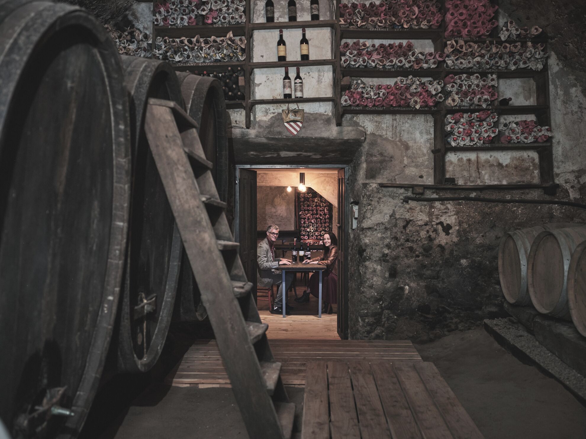 A cellar with wooden barrels and wine racks.