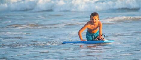 A person on a blue surfboard in the ocean.