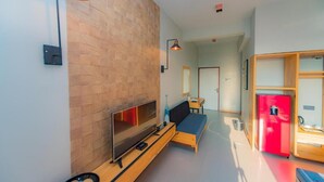 A modern living room with a flat-screen TV, wooden furniture, and a red refrigerator. - Ballena-Mirissa (Mirissa)