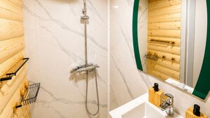 Une salle de bain moderne avec une douche, un panneau mural en bois, un mur recouvert de carreaux de marbre et un miroir avec un cadre vert.