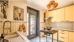 Uma cozinha moderna com uma pia, uma mesa com uma tigela e um quadro de um veado na parede.