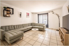 A modern living room with a sectional sofa, a round coffee table, and a floor lamp. - Comme une évidence - Town house for 8 people (Carcassonne)