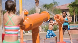 Niños jugando cerca de fuentes de agua al aire libre.