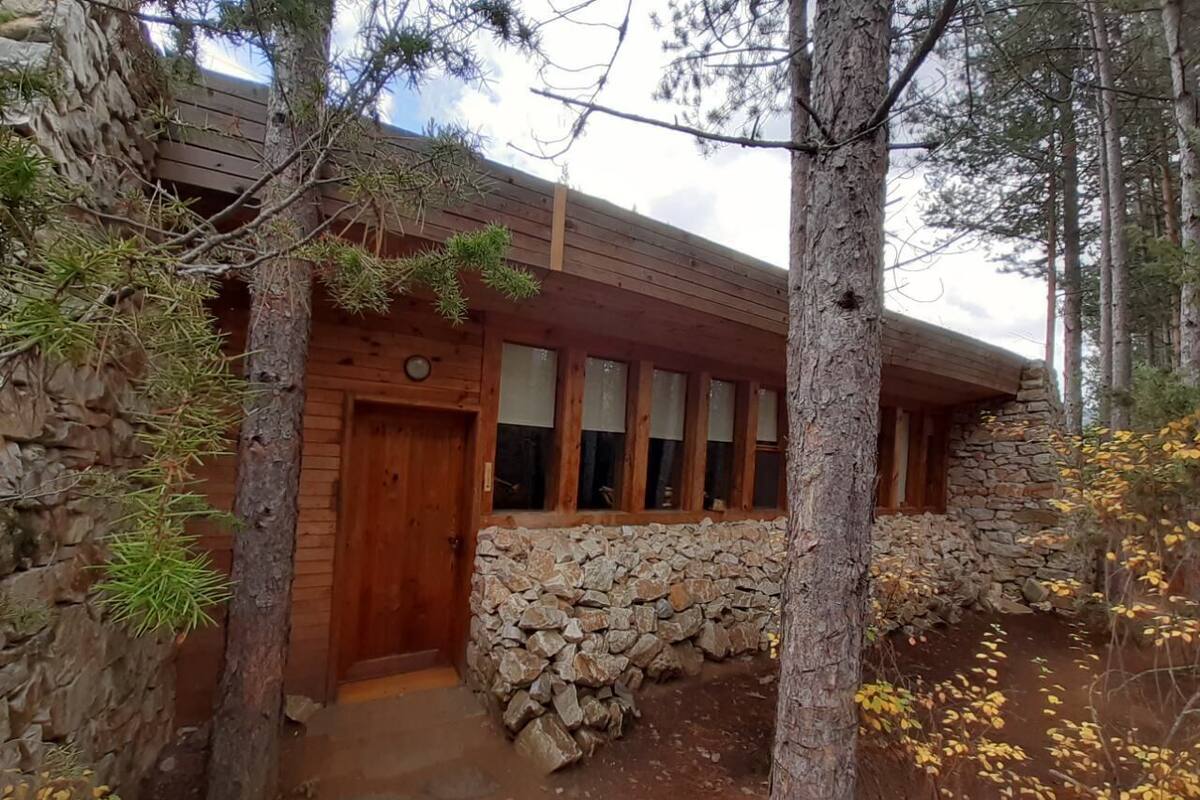 Un chalet rustique avec un mur en pierre, une porte en bois et des fenêtres.