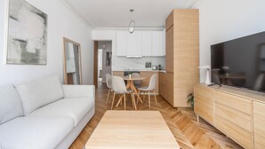 A modern living room with a sofa, dining table, and TV. - We Parisian * Invalides* Cozy Home (Paris)
