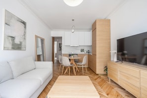 A modern living room with a sofa, dining table, and TV. - We Parisian * Invalides* Cozy Home (Paris)