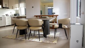 Une cuisine moderne avec un coin repas, comprenant un îlot central, des chaises et un réfrigérateur.