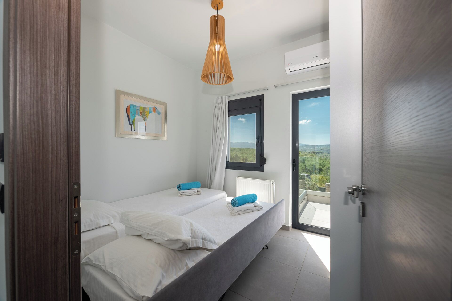 Ein Schlafzimmer mit zwei Betten, einem Fenster mit Aussicht, einer Deckenleuchte und einer Klimaanlage.