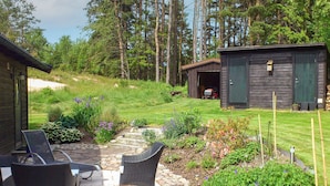 A patio with wicker furniture, a stone pathway, and a small garden with various plants. - 6 Person Holiday Home in Hunnebostrand (Kungshamn)